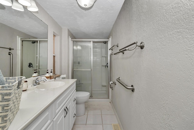 bathroom featuring a textured ceiling, tile patterned flooring, vanity, and a shower stall