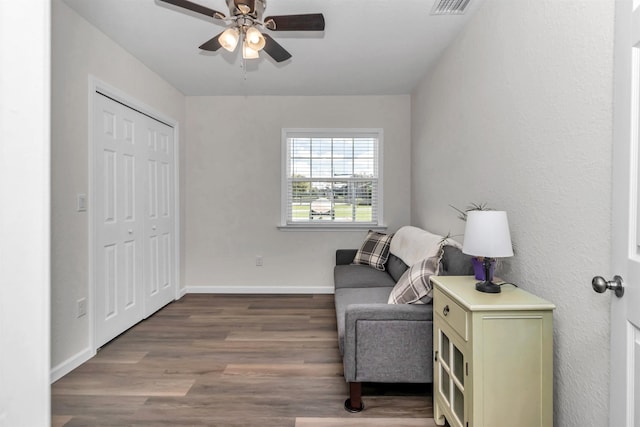 sitting room featuring dark wood-style floors, baseboards, and a ceiling fan