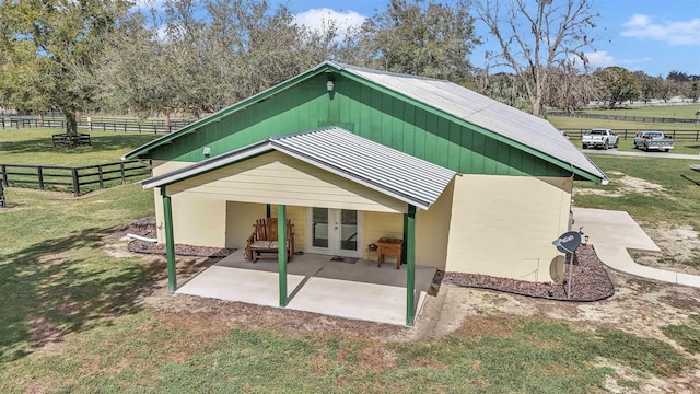 back of property with french doors, a yard, a patio area, metal roof, and fence