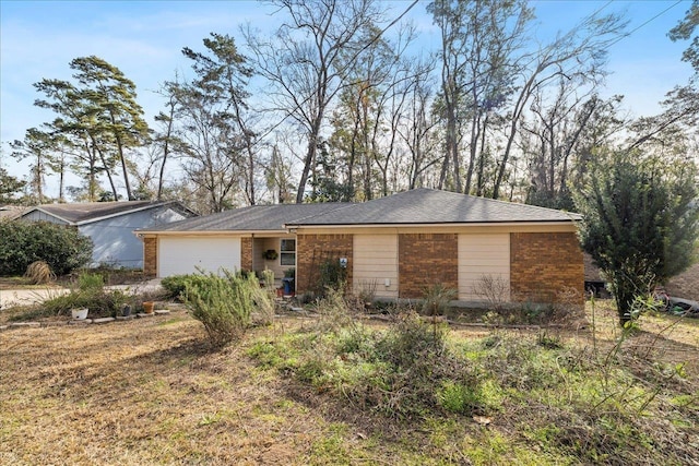 view of front of home with a garage and brick siding