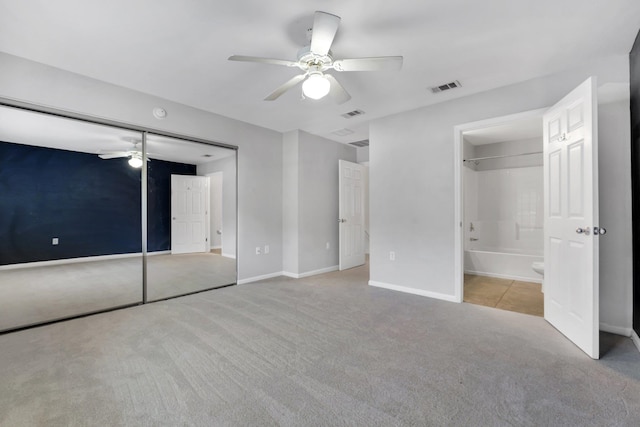 unfurnished bedroom featuring light colored carpet, ceiling fan, and a closet