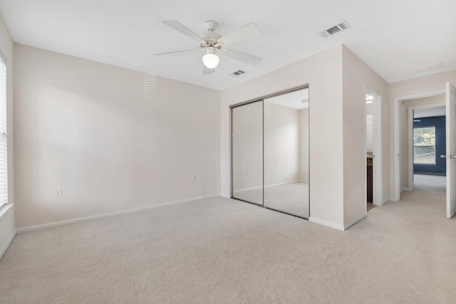 unfurnished bedroom with a closet, light carpet, and ceiling fan