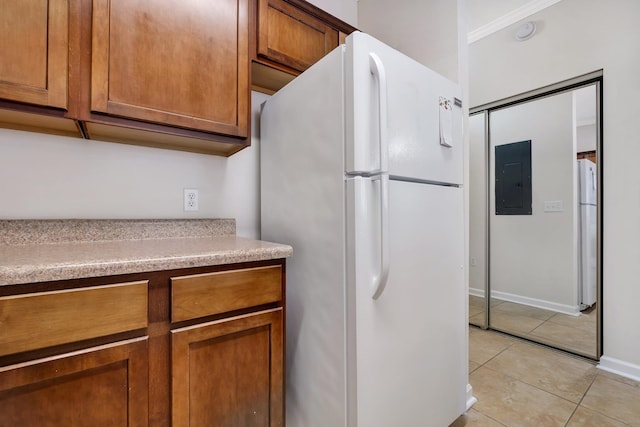 kitchen with electric panel, light tile patterned floors, and white fridge