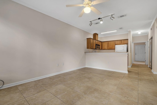 2400 Fred Smith Rd Unit 202, Tallahassee, FL 32303 - kitchen featuring stainless steel microwave, light tile patterned floors, brown cabinetry, refrigerator, and crown molding