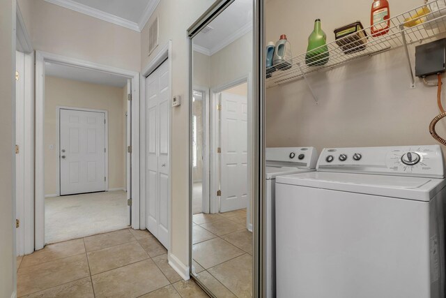 2400 Fred Smith Rd Unit 202, Tallahassee, FL 32303 - washroom featuring crown molding, washing machine and dryer, light carpet, and light tile patterned floors