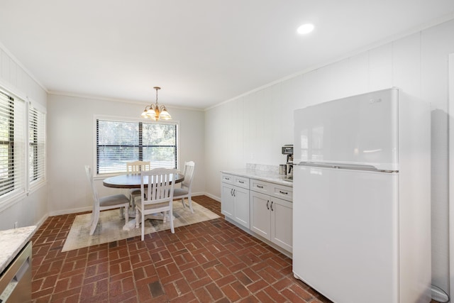 dining area with brick patterned floor, a chandelier, and ornamental molding