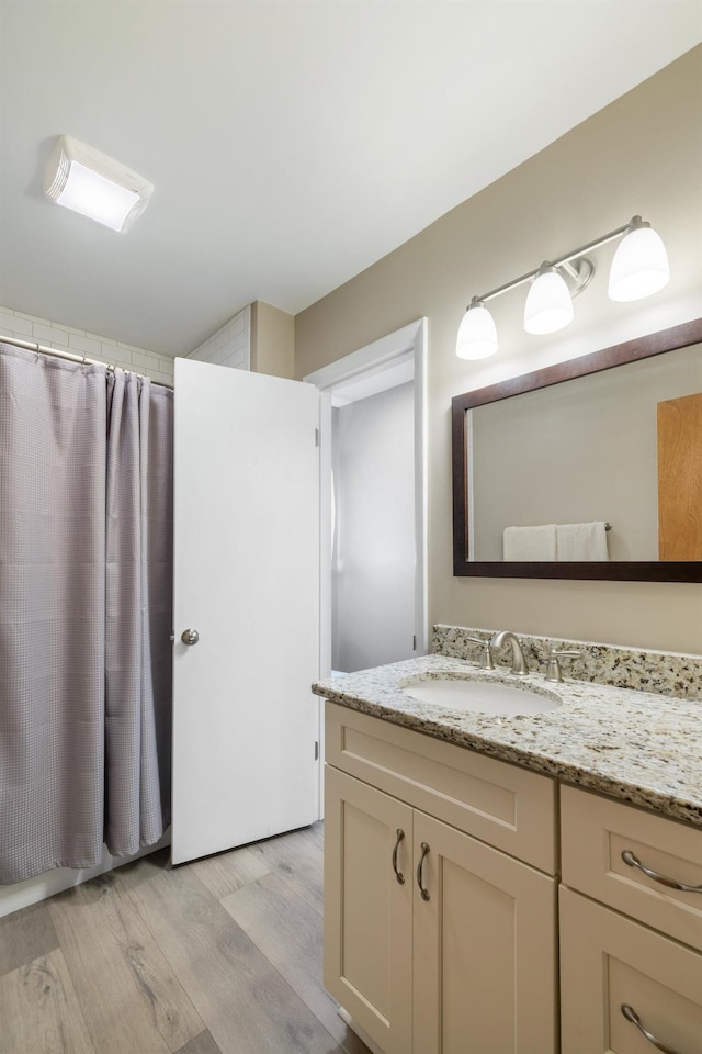 bathroom with wood finished floors, curtained shower, and vanity