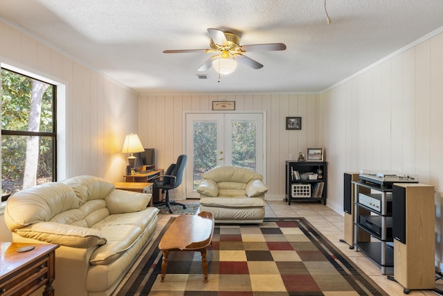 living room with french doors, visible vents, ceiling fan, crown molding, and light tile patterned floors