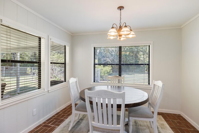 dining space featuring brick floor, baseboards, a notable chandelier, and crown molding