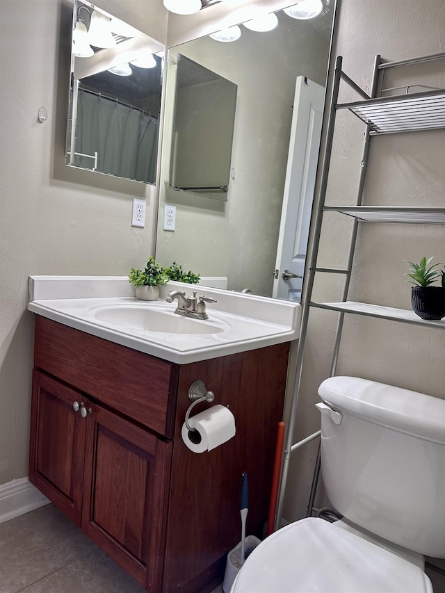 bathroom with toilet, tile patterned flooring, and vanity