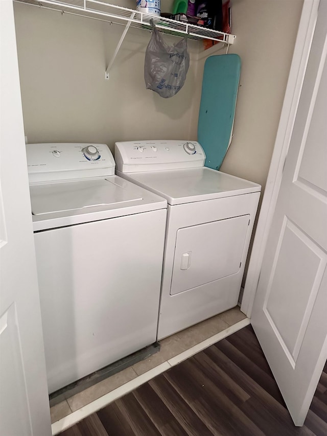 clothes washing area with dark wood-style floors, laundry area, and washing machine and dryer