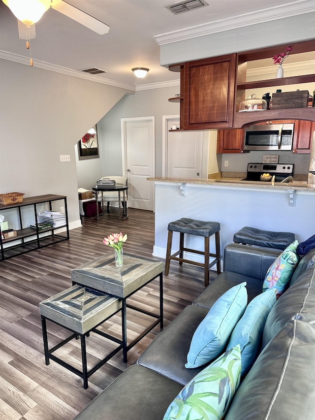 living area featuring dark wood-style floors, ceiling fan, visible vents, and crown molding