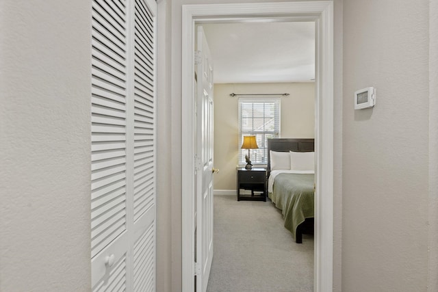 bedroom with carpet flooring, a textured wall, and baseboards
