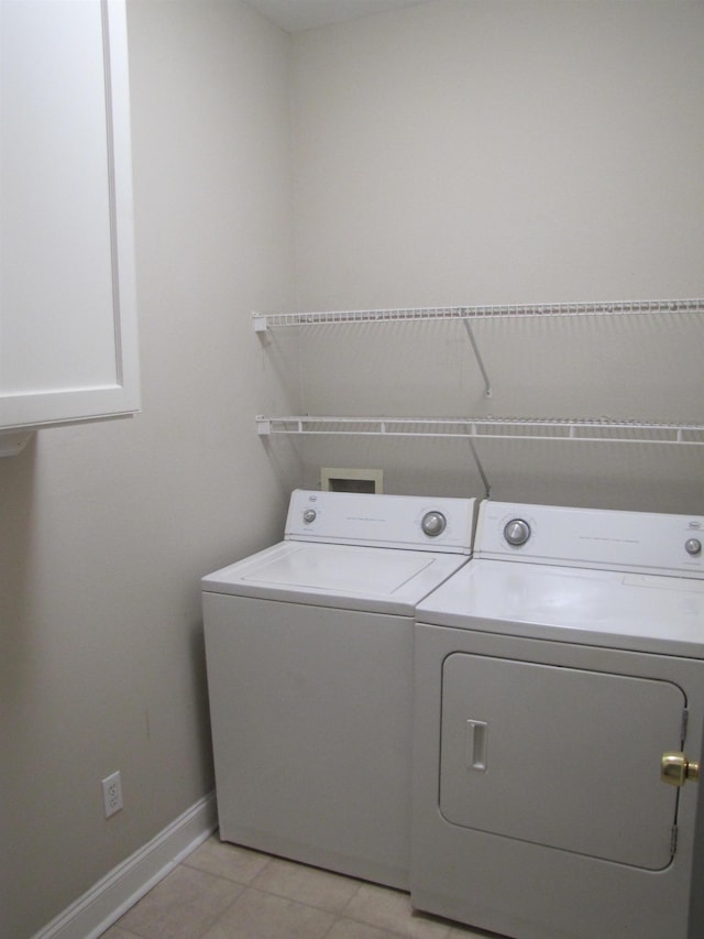 laundry area featuring washing machine and dryer, baseboards, laundry area, and light tile patterned floors