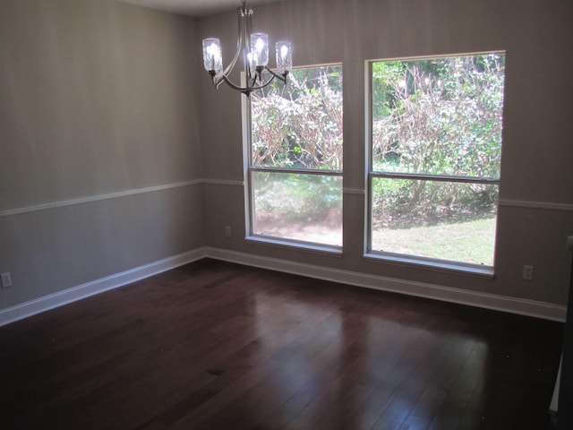 unfurnished dining area featuring an inviting chandelier, dark wood-style flooring, and a wealth of natural light