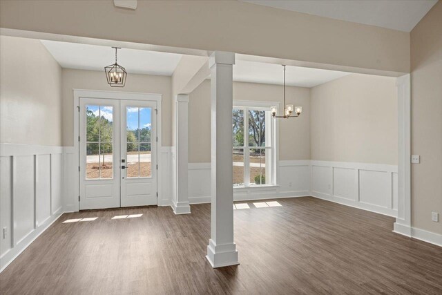 foyer with dark hardwood / wood-style floors, a healthy amount of sunlight, french doors, and an inviting chandelier