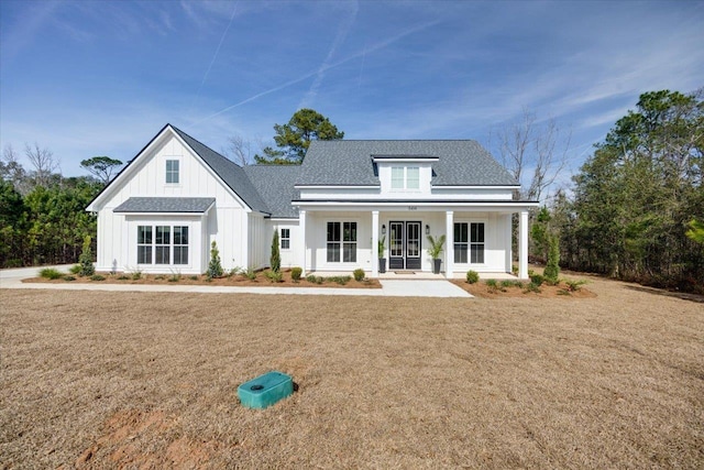 rear view of house featuring a porch and a yard