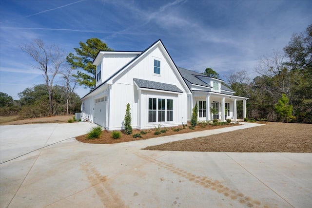 modern farmhouse with covered porch, a garage, and central air condition unit