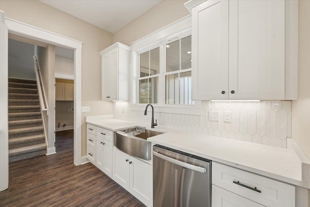 kitchen with white cabinets, light stone counters, dark wood-type flooring, sink, and dishwasher