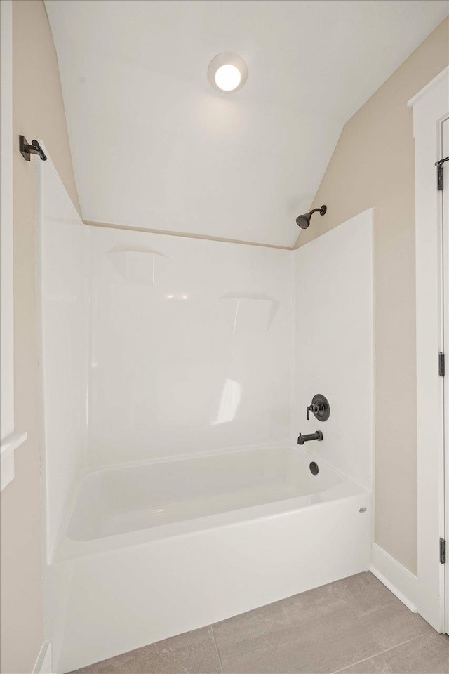 bathroom featuring vaulted ceiling and bathtub / shower combination