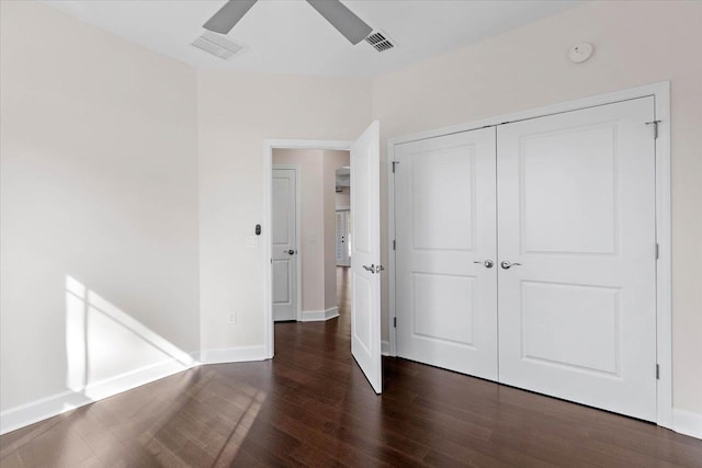 unfurnished bedroom featuring a closet, dark hardwood / wood-style floors, and ceiling fan