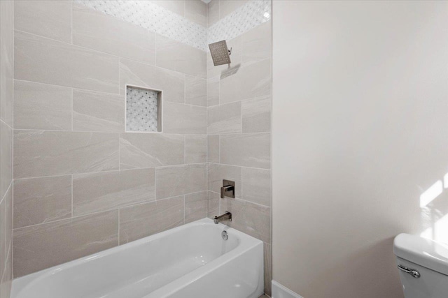 bathroom with toilet and tiled shower / bath combo