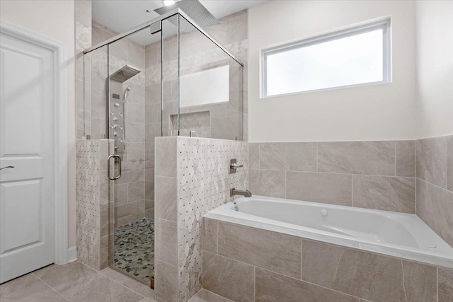 bathroom with tile patterned floors and shower with separate bathtub