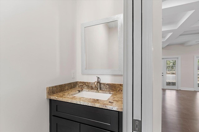 bathroom with wood-type flooring, coffered ceiling, vanity, and beam ceiling