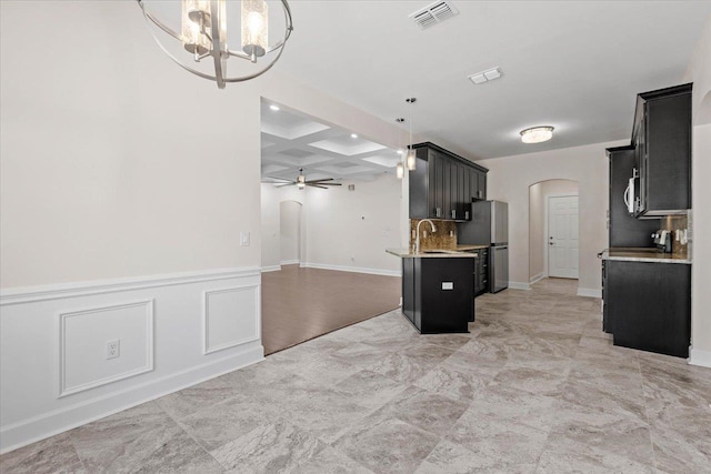 kitchen featuring pendant lighting, sink, coffered ceiling, ceiling fan with notable chandelier, and beamed ceiling