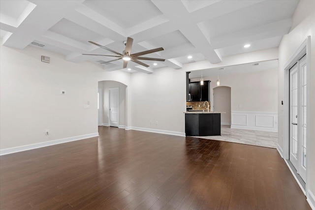 unfurnished living room featuring sink, dark wood-type flooring, ceiling fan, coffered ceiling, and beamed ceiling