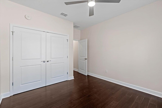 unfurnished bedroom featuring dark hardwood / wood-style floors, ceiling fan, and a closet