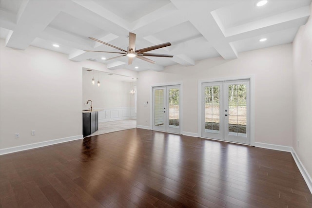 unfurnished living room featuring beam ceiling, coffered ceiling, dark hardwood / wood-style floors, and french doors