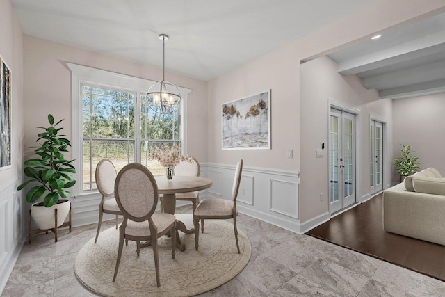 dining room featuring beamed ceiling and a chandelier