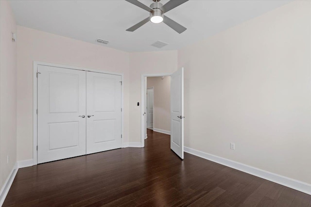 unfurnished bedroom featuring dark wood-type flooring, ceiling fan, and a closet