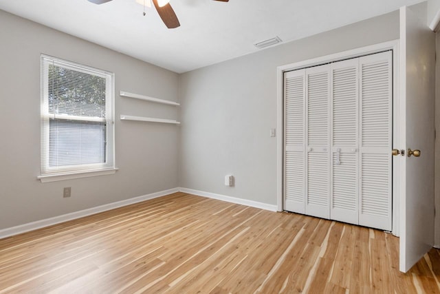 unfurnished bedroom with a closet, hardwood / wood-style flooring, and ceiling fan