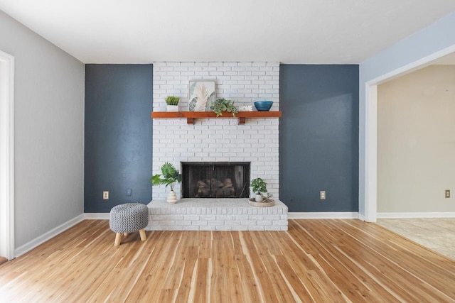 living room with hardwood / wood-style flooring and a brick fireplace