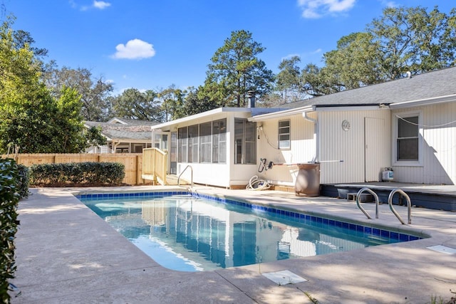 view of pool with a sunroom and a patio area