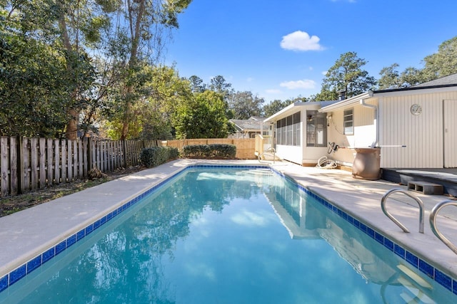 view of swimming pool featuring a patio and a sunroom