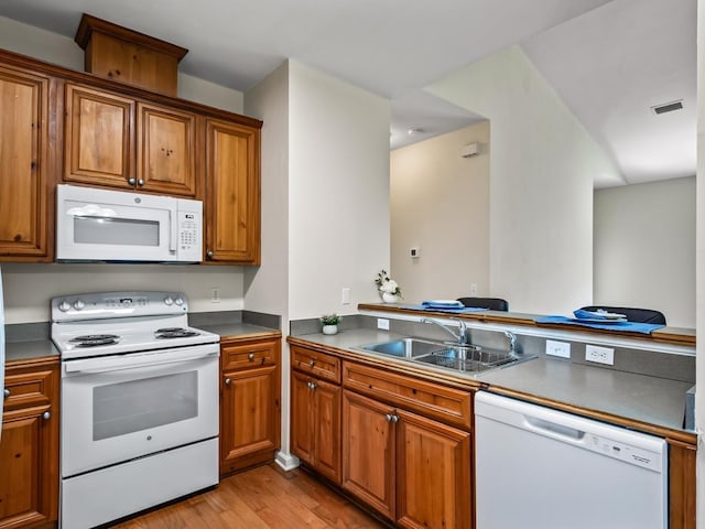 325 Chastain Ln, Tallahassee, FL 32305 - kitchen featuring a sink, a peninsula, brown cabinetry, light wood-style flooring, and white appliances