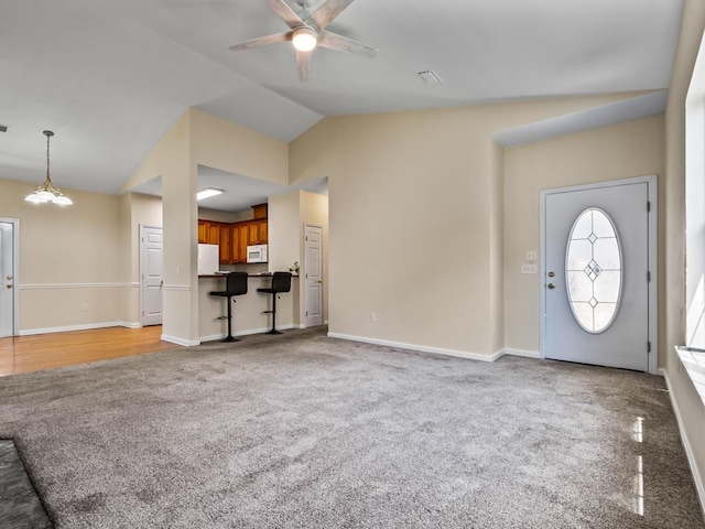 325 Chastain Ln, Tallahassee, FL 32305 - unfurnished living room with carpet flooring, visible vents, baseboards, ceiling fan with notable chandelier, and vaulted ceiling