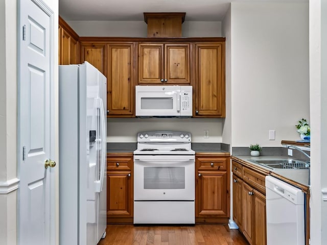 325 Chastain Ln, Tallahassee, FL 32305 - kitchen featuring light wood-style flooring, white appliances, brown cabinets, and a sink