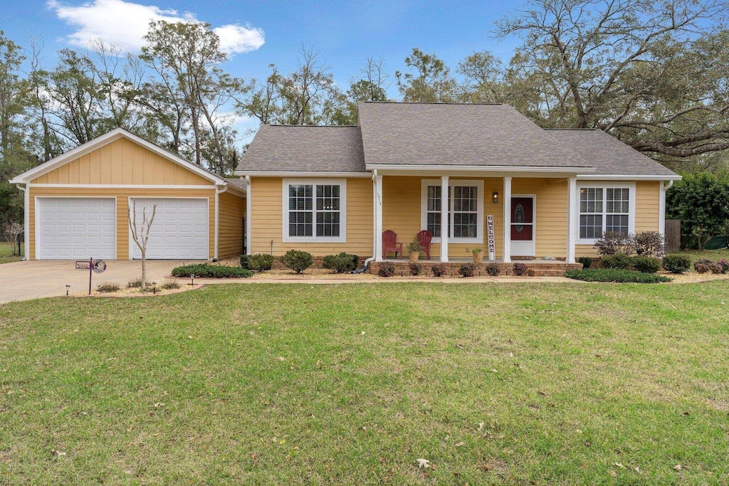 10715 Sycamore Ridge Ln, Tallahassee, FL 32305 - ranch-style home with covered porch, a front lawn, roof with shingles, and a garage