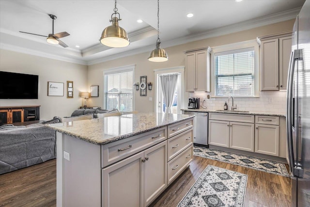 kitchen with a kitchen island, decorative light fixtures, dark hardwood / wood-style flooring, stainless steel appliances, and sink