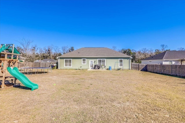 back of property with a playground, a trampoline, a yard, and a patio