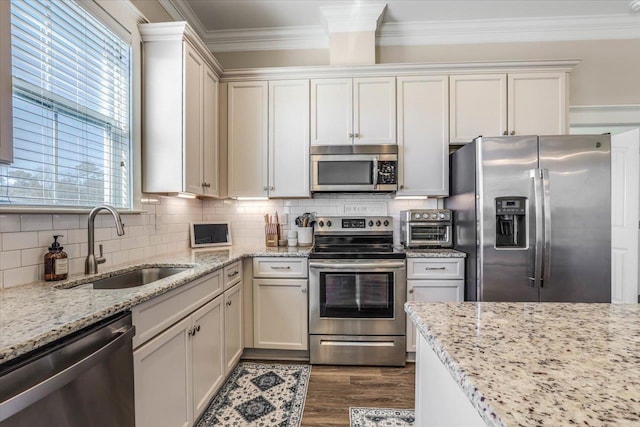 kitchen featuring stainless steel appliances, decorative backsplash, light stone counters, and sink