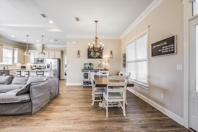 dining area featuring a healthy amount of sunlight, ornamental molding, and an inviting chandelier