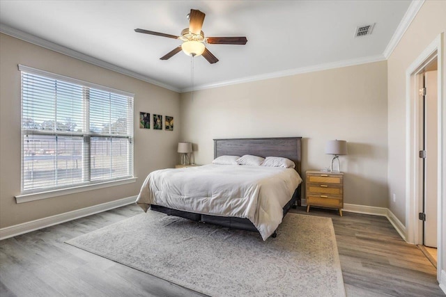 bedroom featuring dark wood-type flooring, ceiling fan, and crown molding