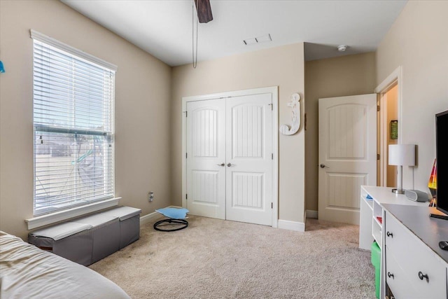 carpeted bedroom featuring ceiling fan and a closet