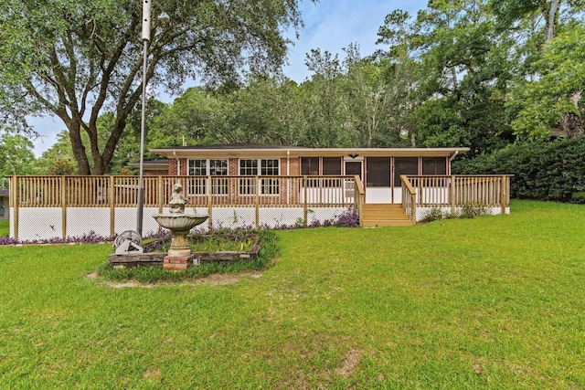 back of property with a wooden deck and a yard