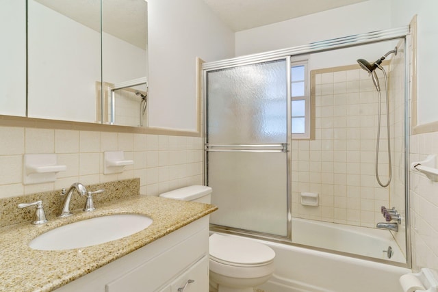 full bathroom featuring tile walls, vanity, combined bath / shower with glass door, and toilet